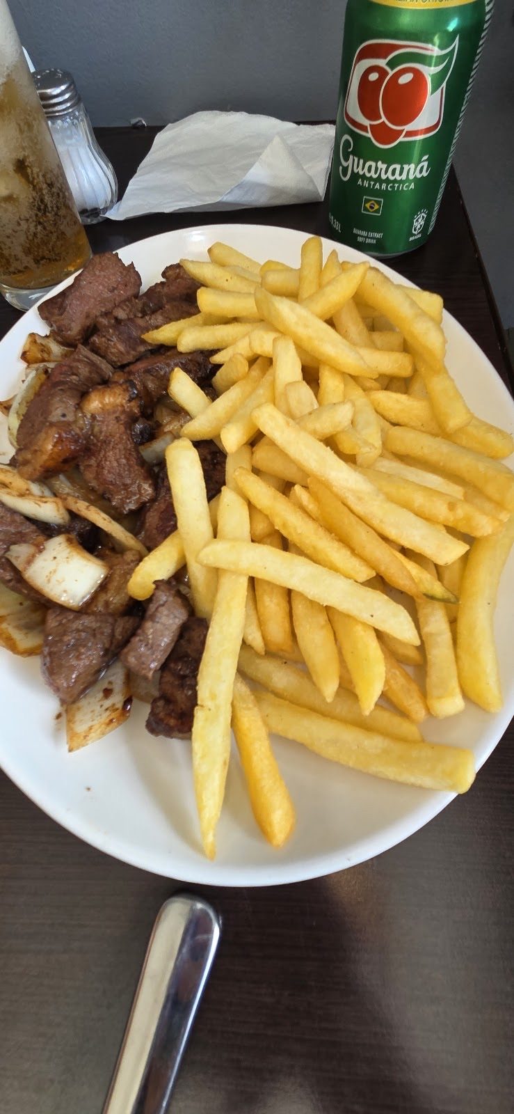 Chopped steak and chips with a can of Brazilian guaraná, cropped away from the burned-in wording